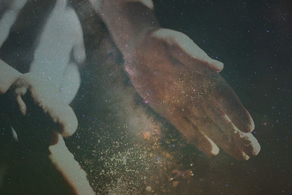 Dust between a pair of hands that look like a small galaxy