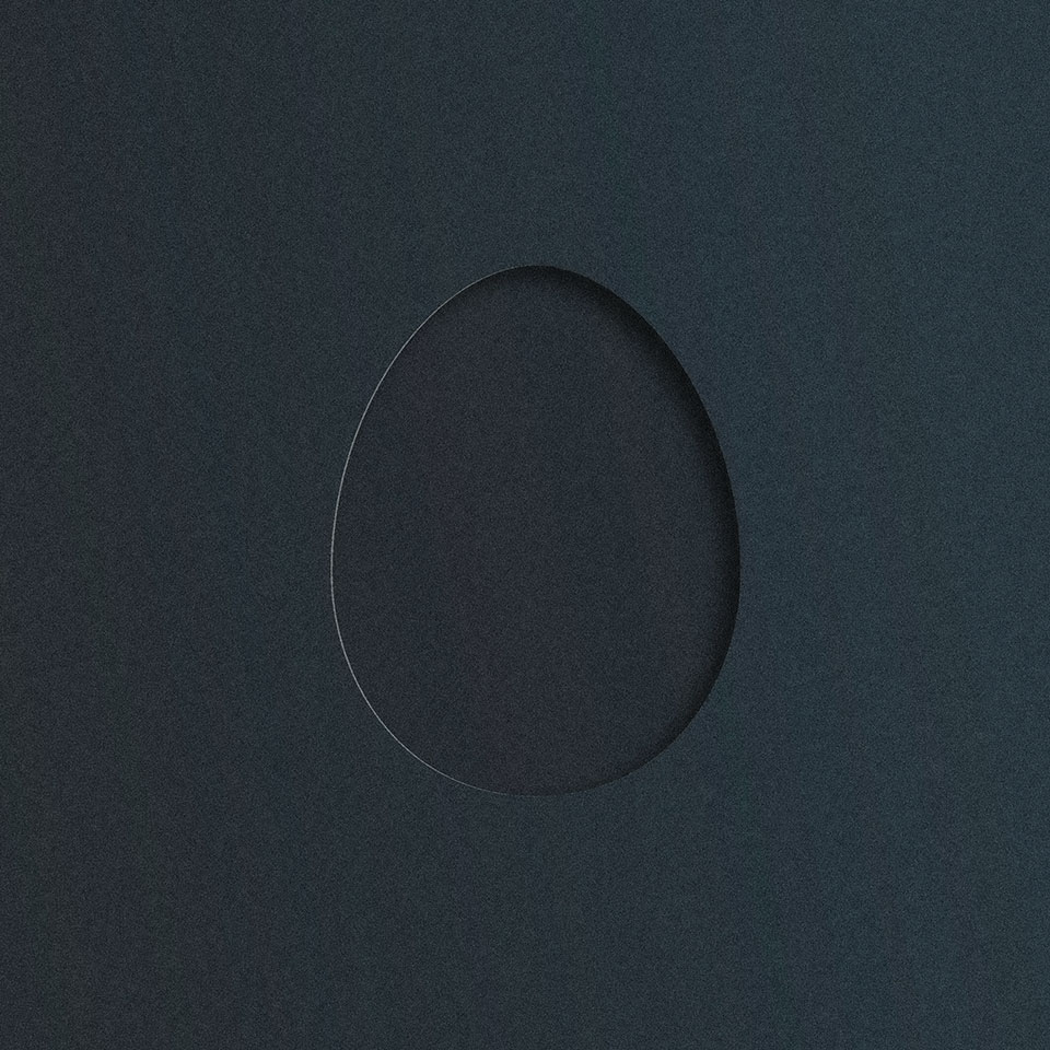 A hole cut out of a piece of black matte card stock, revealing black matte card stock beneath