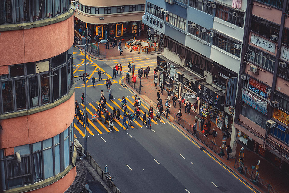 A shot from above as a throng of people cross a city street