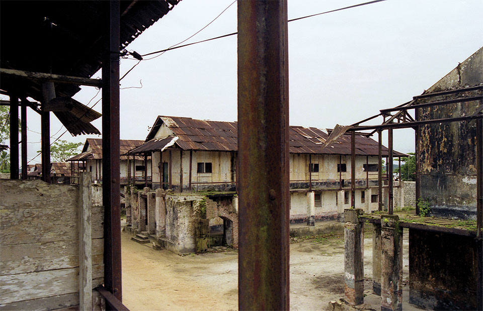 Decrepit buildings stand in an abandoned prison