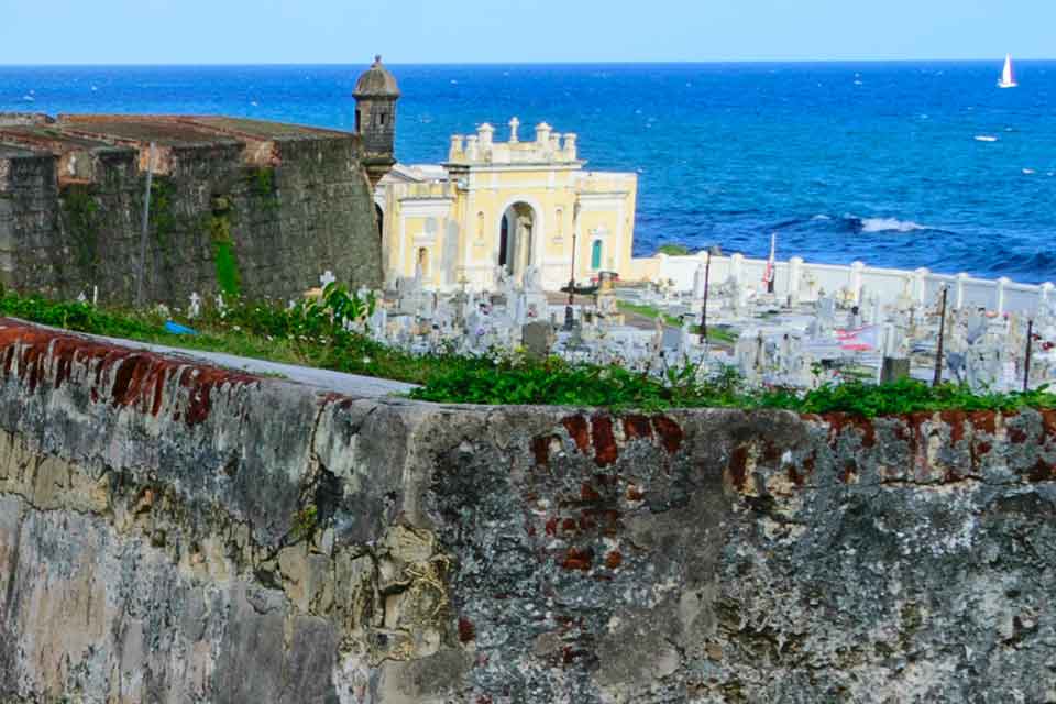 A photograph of a rock-hewn cemetery perched on a rock cliff