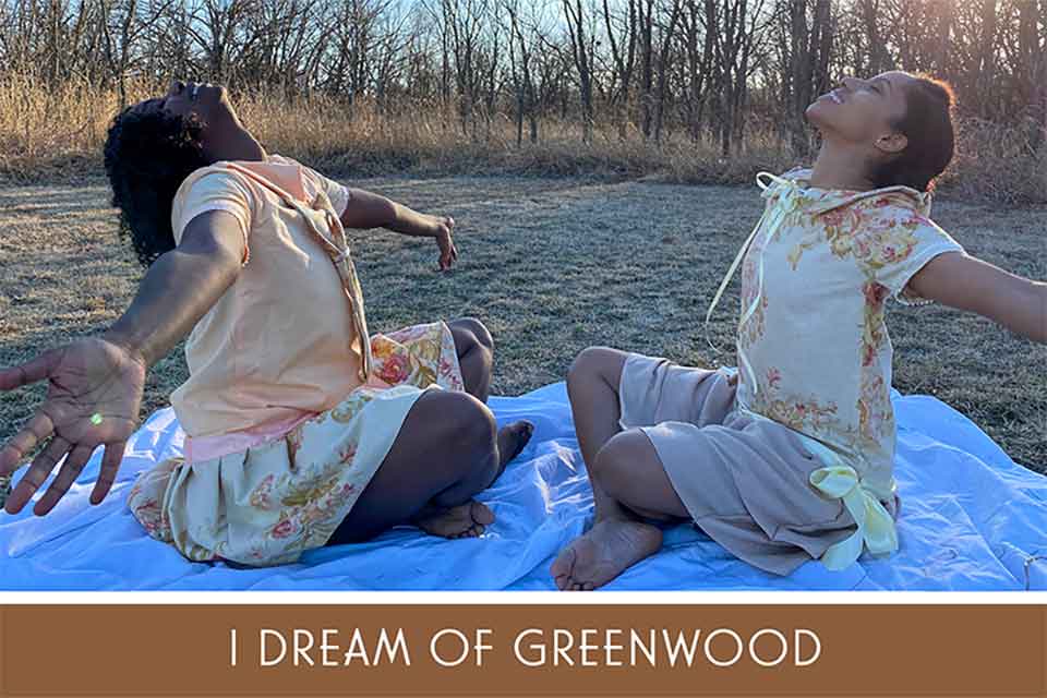 A photograph of two young women, sitting cross-legged on a blue blanket, with their arms outstretched. The text below reads: I Dream of Greenwood