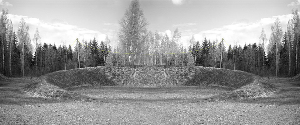 A black and white photograph of a crater, now covered with grass