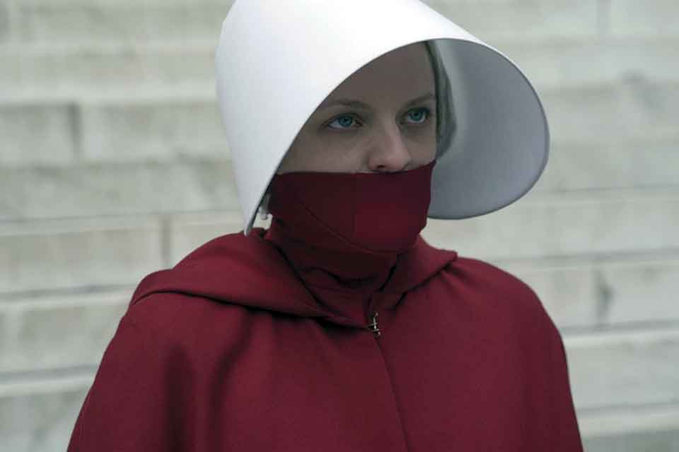 A photograph of a woman in a red cloak and a white hat