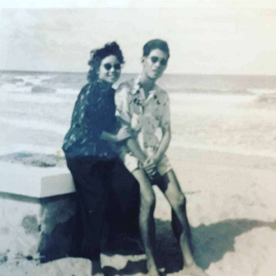 A black and white photograph of Lam's mother and father sitting together on a beach