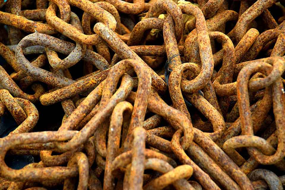 A photograph of a pile of rusted chains