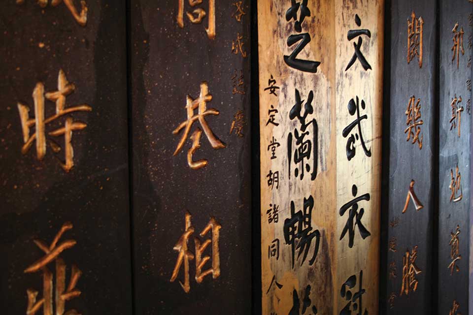 Wooden slats on a wall with Chinese characters on them