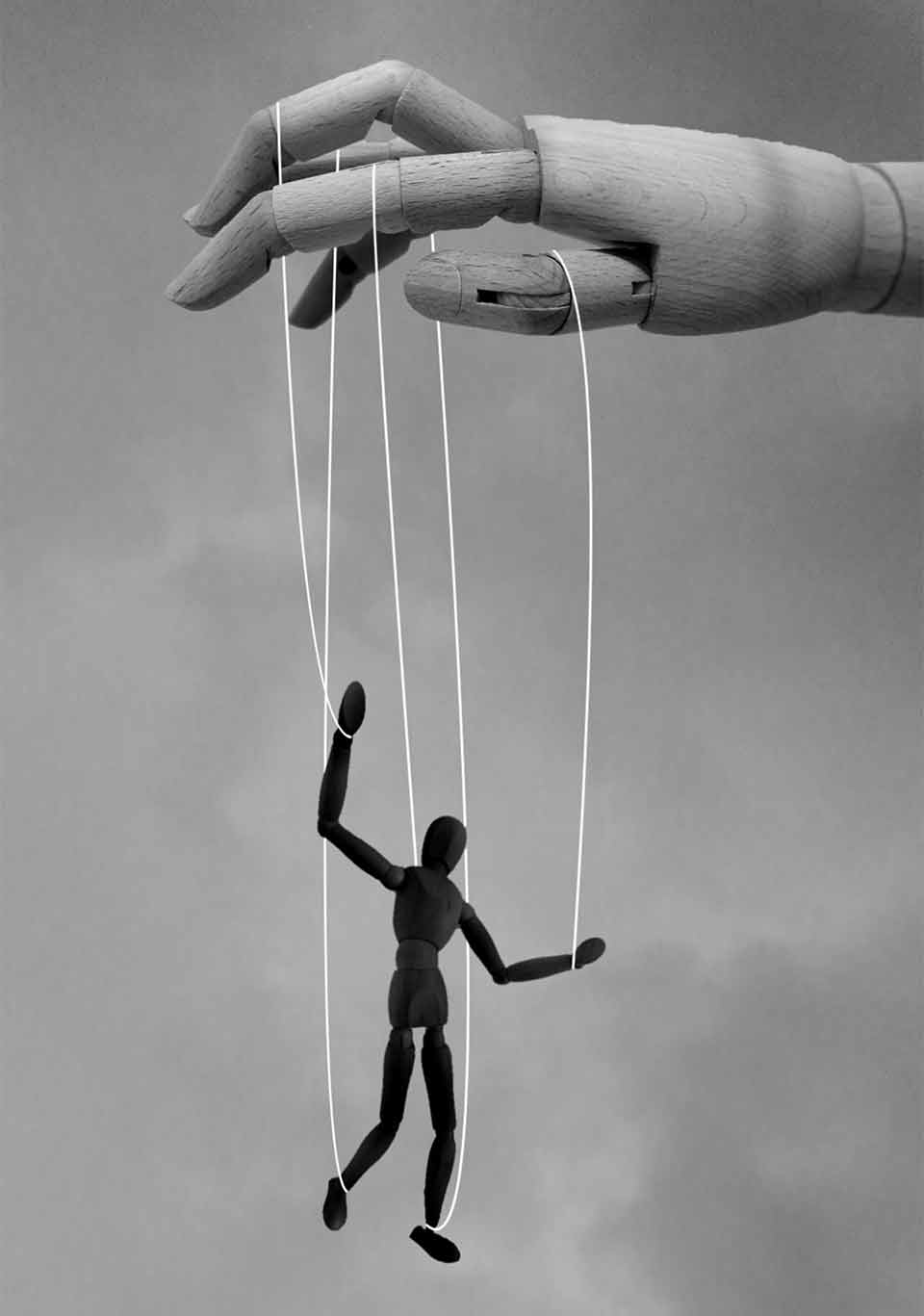 A wooden hand dancing a human figure at the end of strings attached to the fingers
