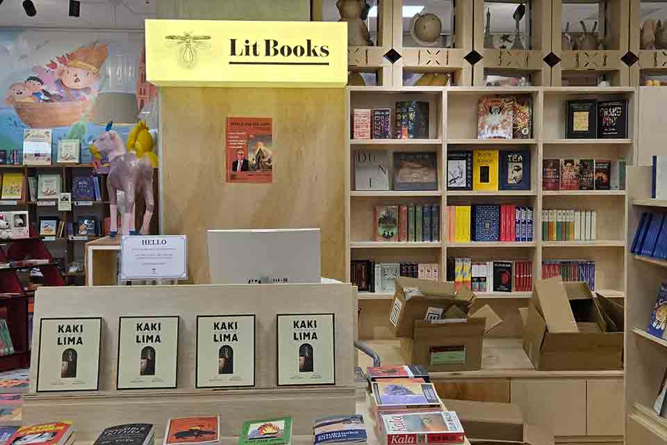 The interior of a bookstore. A sign reads: Lit Books