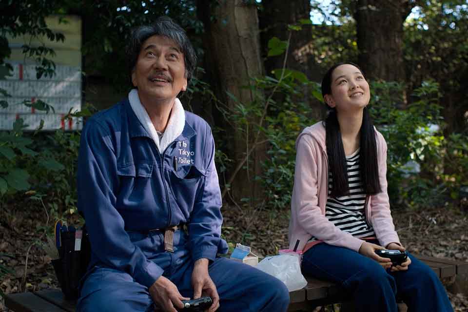 An older man and a younger woman smile while looking up