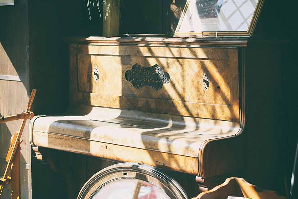 An old console piano covered in dust