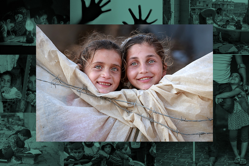 Photo by Fadi Thabet of two young Palestinian girls looking over a tent surrounded by barbed wire