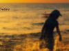 A gauzy photograph of two children playing in the surf. The sun is setting and they are mostly swallowed in shadow