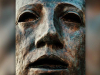 A close up of a human face in bronze