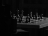 A chessboard in a room consumed by shadows