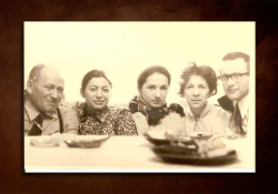An aged picture of a family gathered around a table