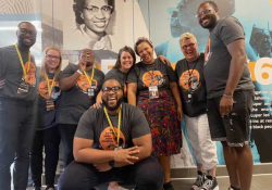 A group of people stand smiling at the viewer