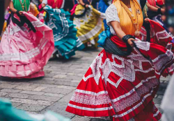 The lower torso of women in traditional Mexican dress dancing in tandem