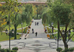 A paved walkway juts out into a natural landscape in an urban park