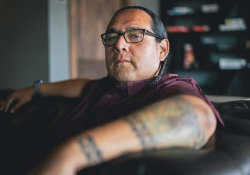 A photograph of Oscar Hokeah sitting in a chair looking at the viewer