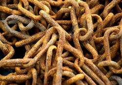 A photograph of a pile of rusted chains