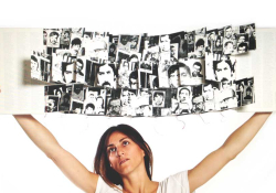 A woman holds up a book filled with illustrations above her head